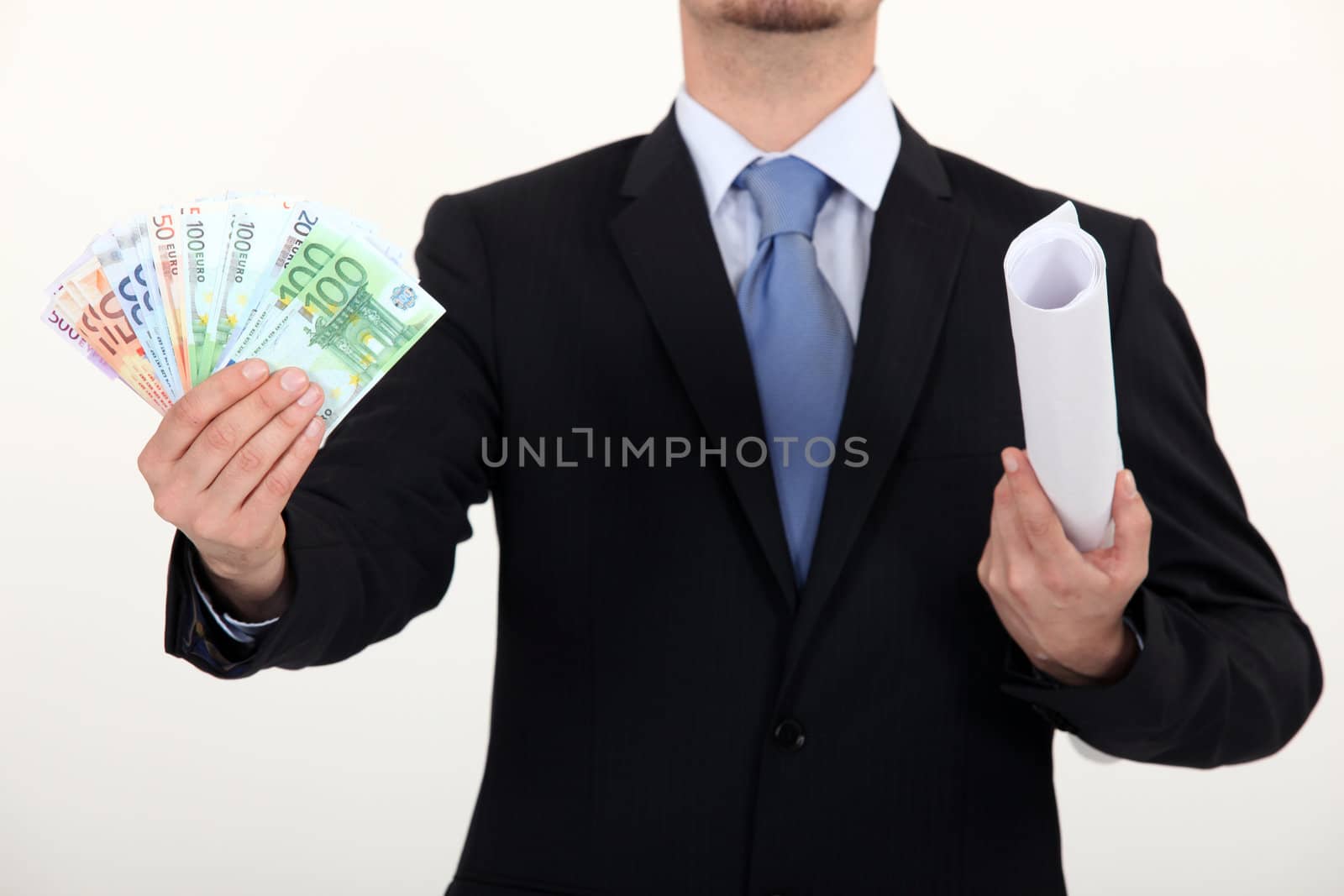 Businessman holding plans and a pile of cash by phovoir