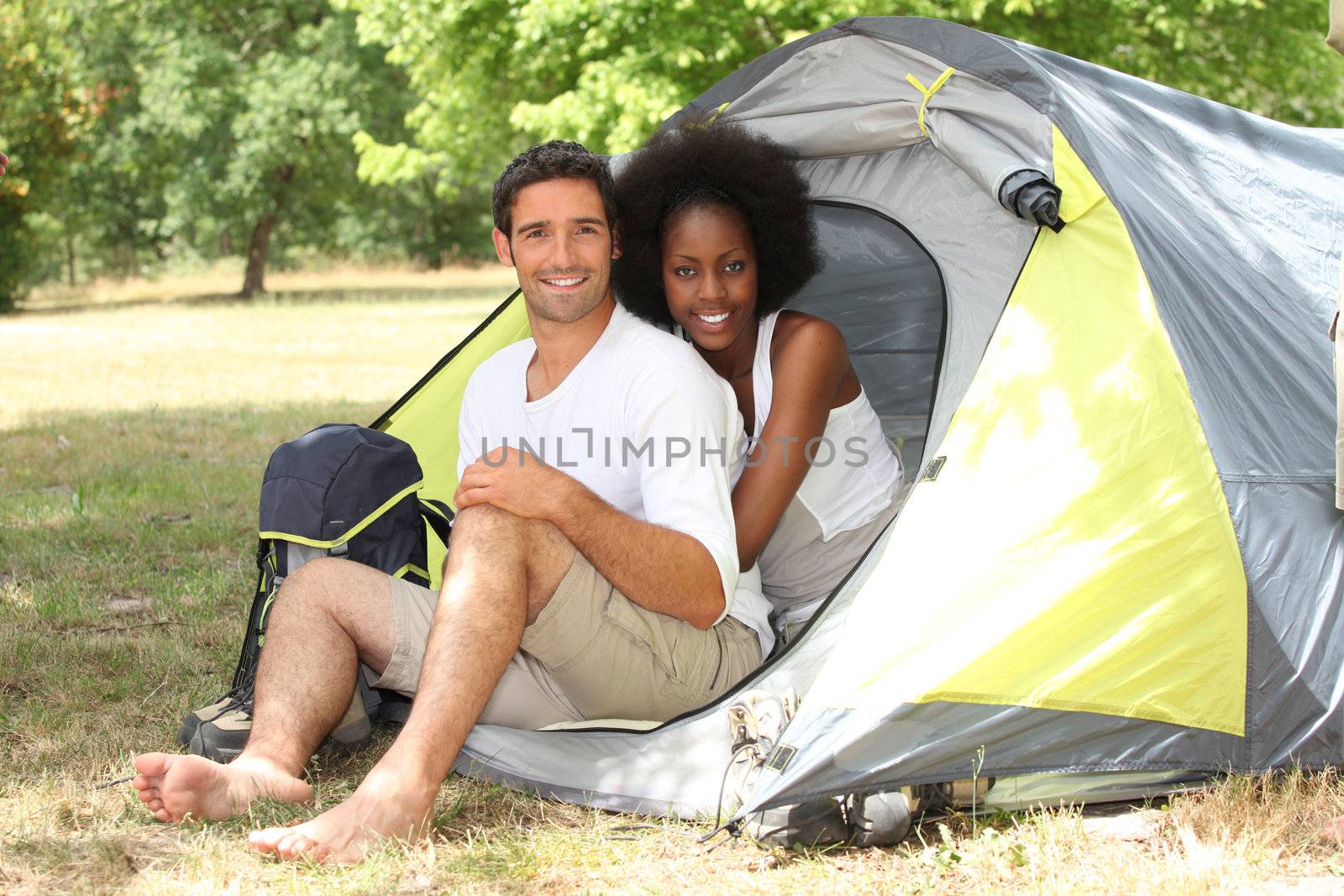 Happy couple sat by entrance to tent by phovoir