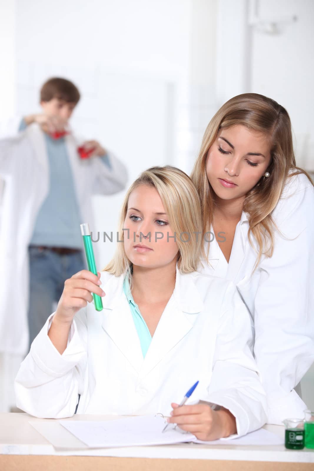 Three classmates in science laboratory