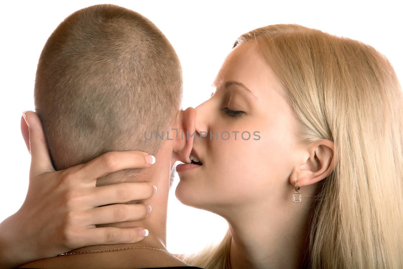 The girl bites an ear of the young man on a white background