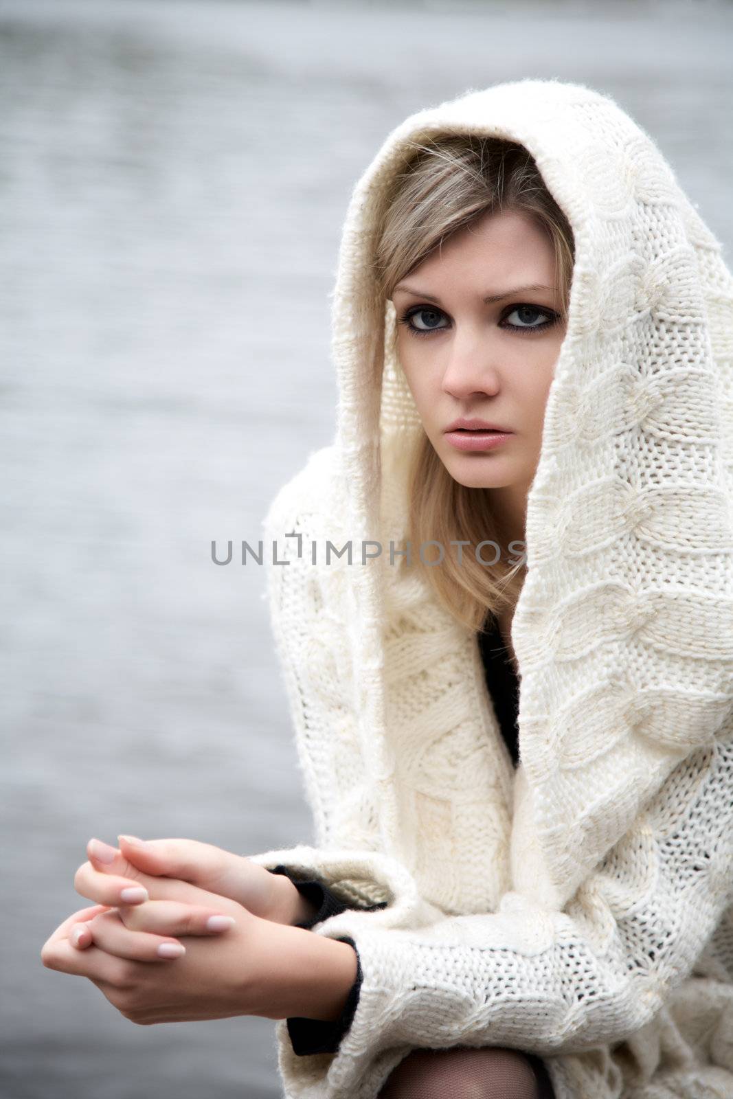 The beautiful girl in a dress with a hood against  river