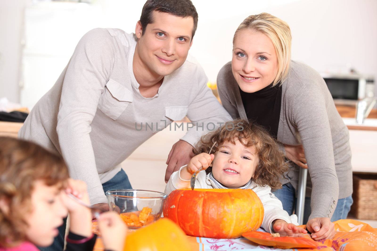 Family carving pumpkins together by phovoir