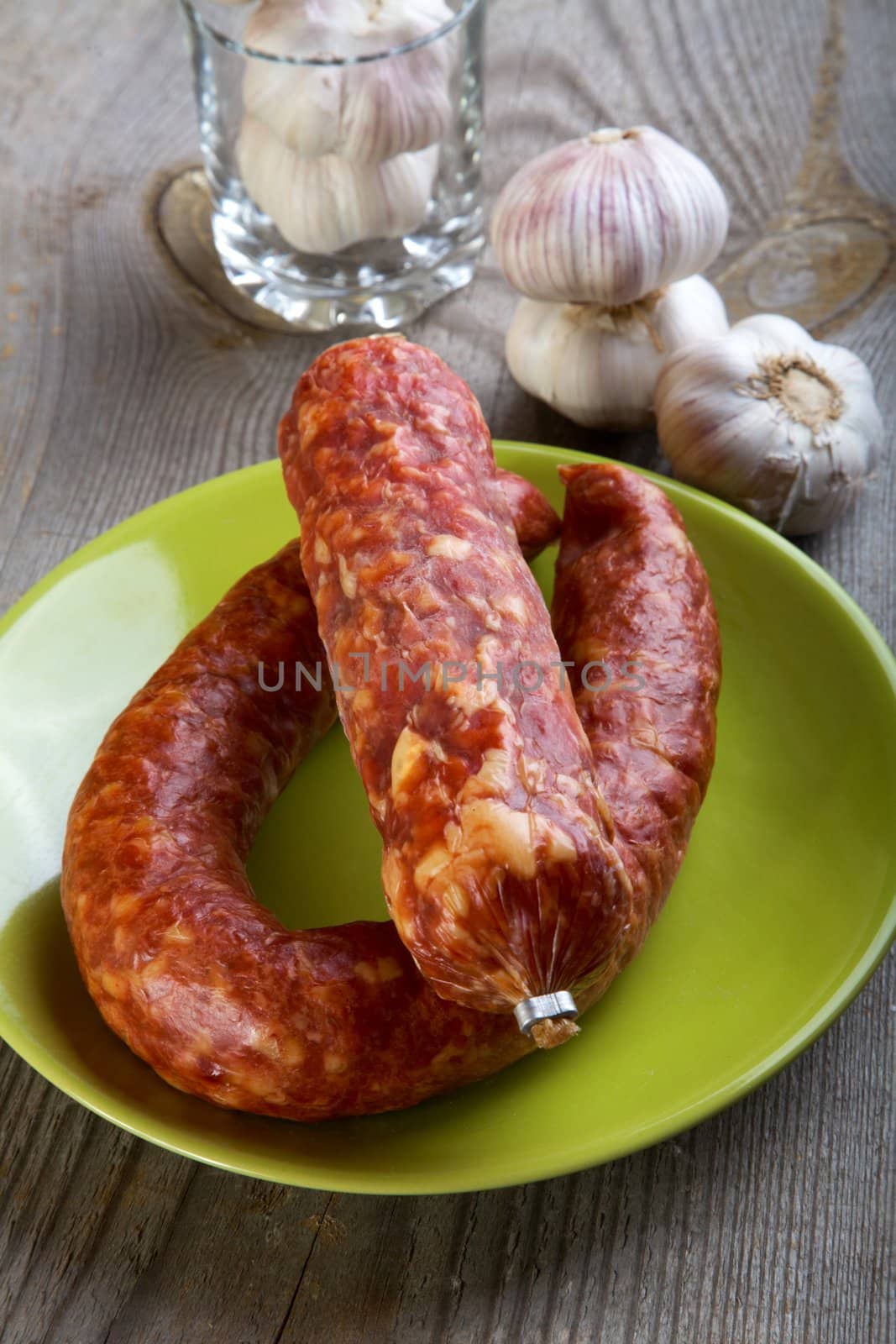 Still-life with sausage and garlic on a wooden table