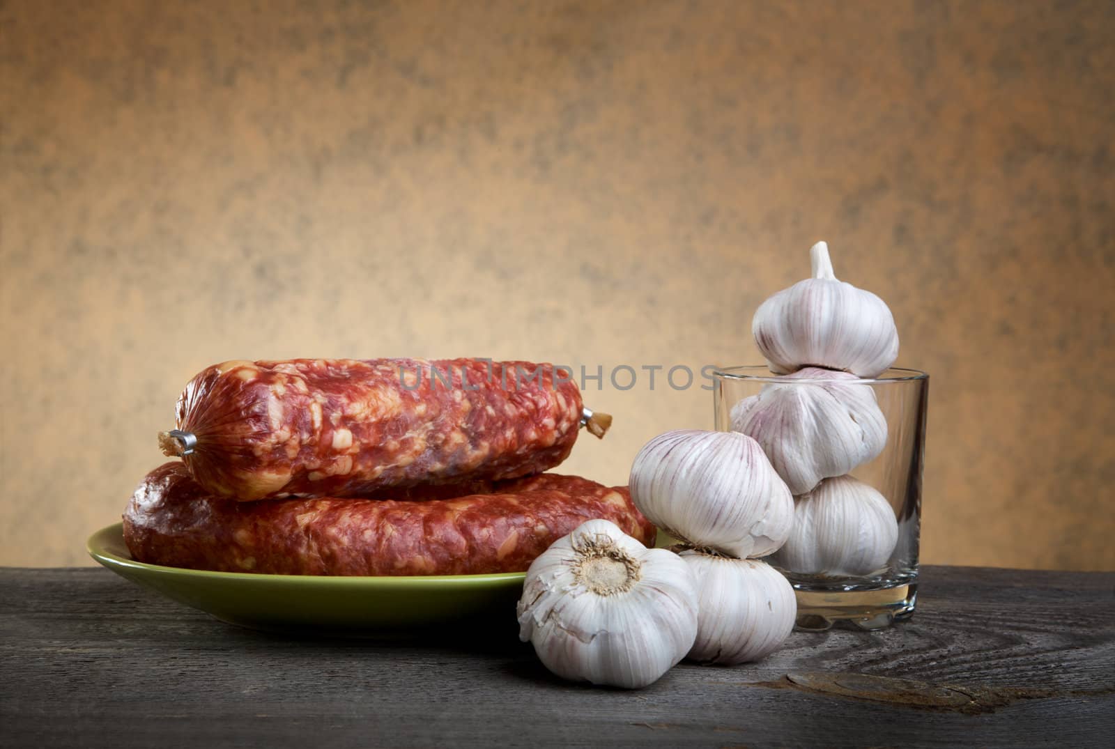 Still-life with sausage and garlic on a wooden table