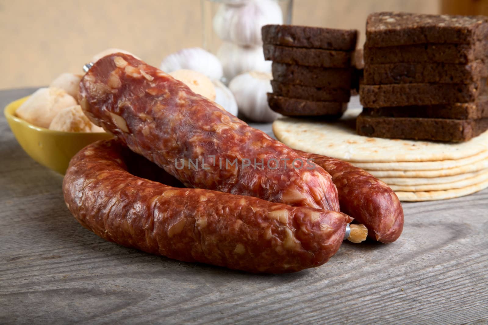 Still-life with sausage and bread on a wooden table