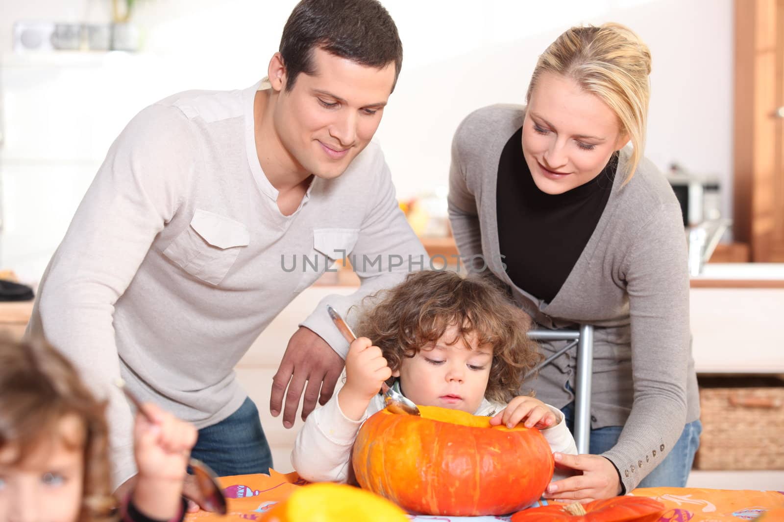 Family carving a pumpkin by phovoir