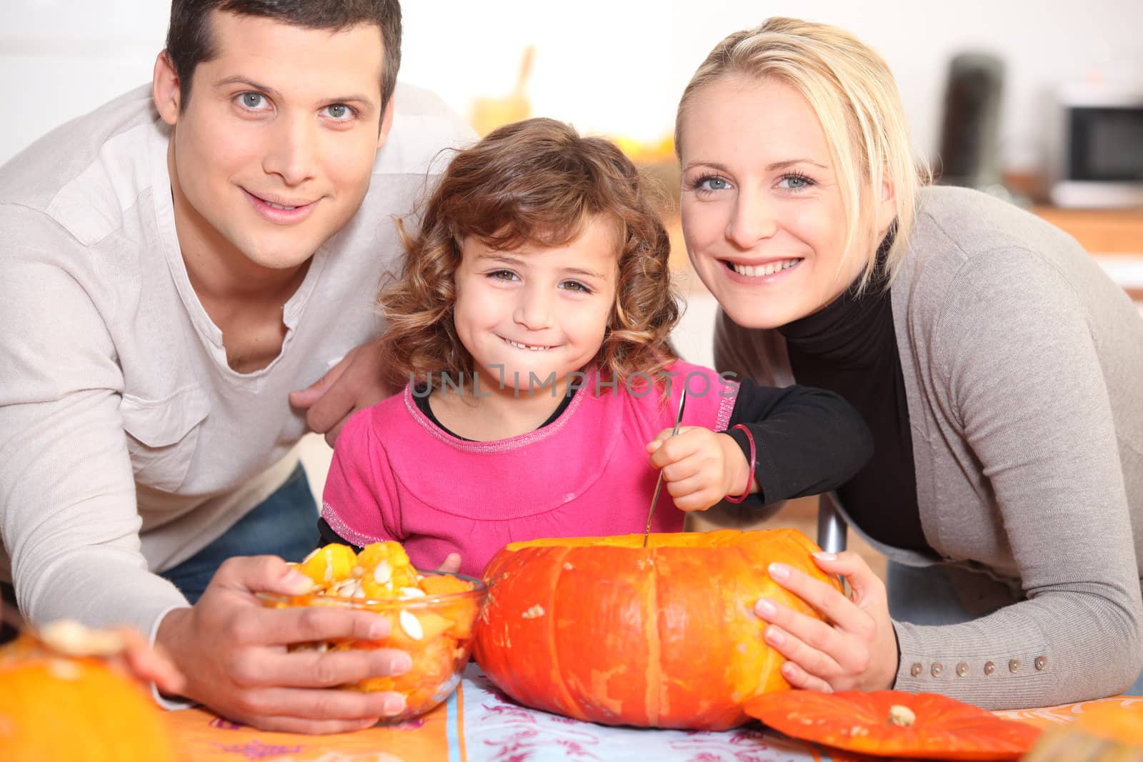 A family carving a pumpkin.