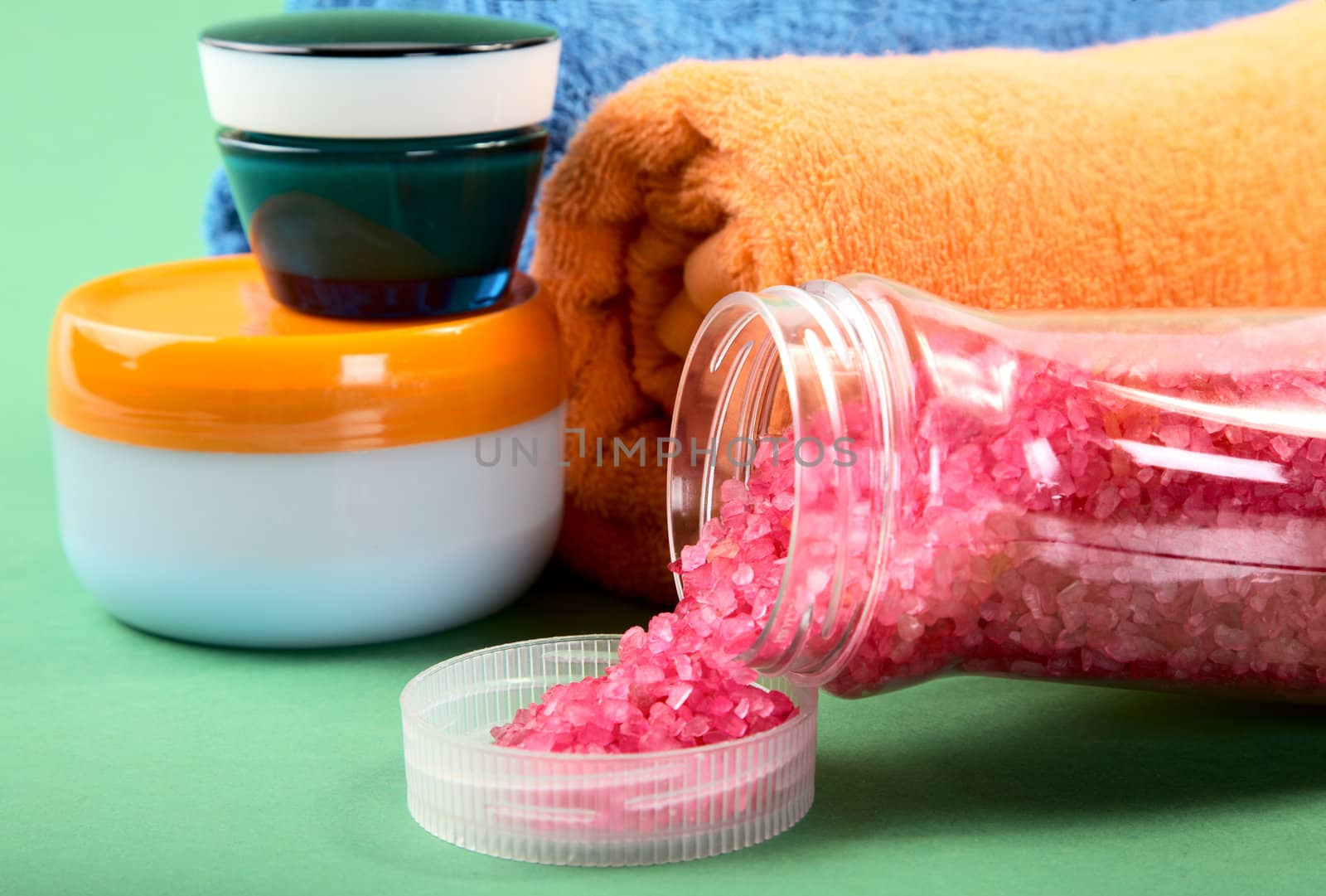 Cosmetic cream and towels on a green background