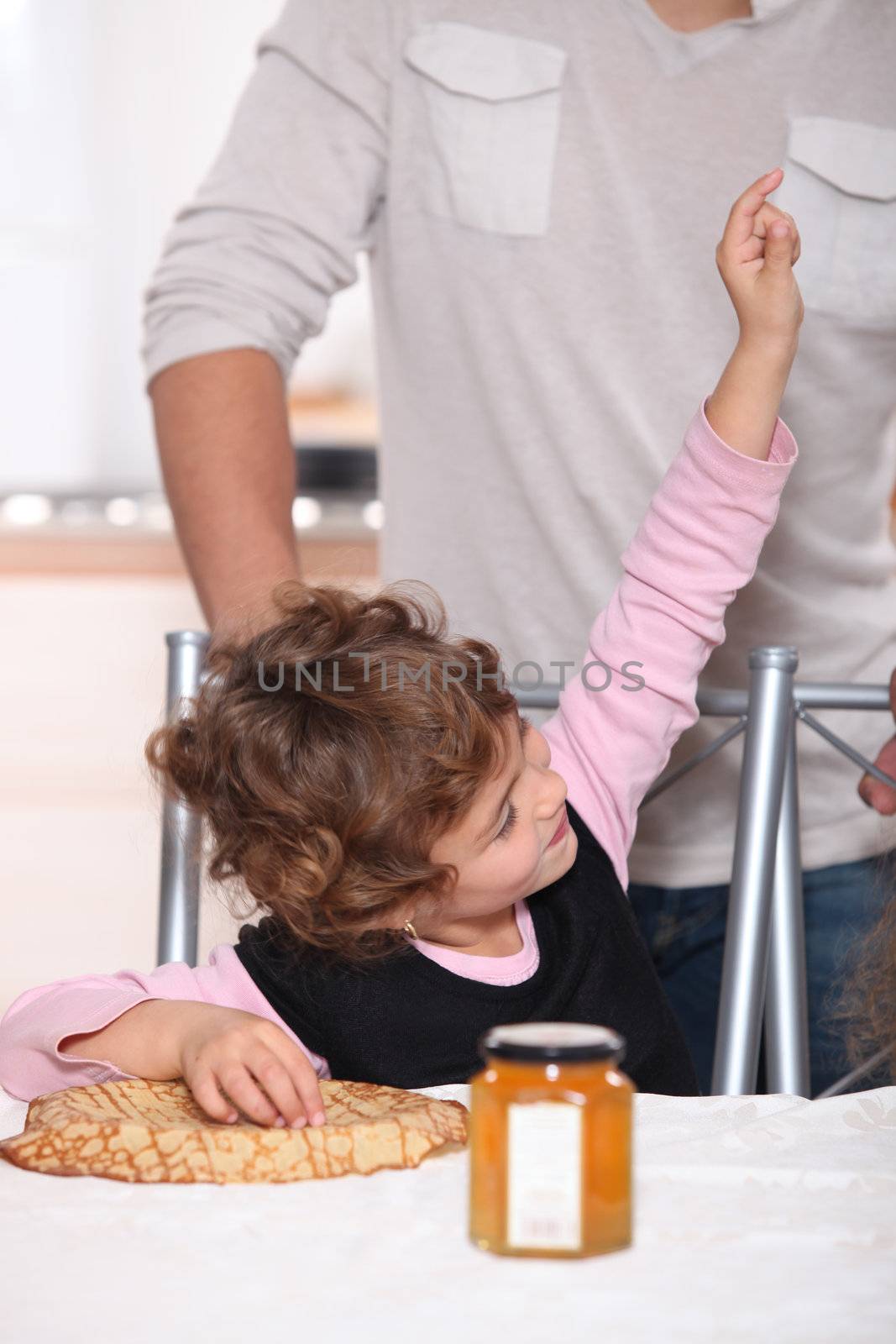 Happy child eating pancakes by phovoir