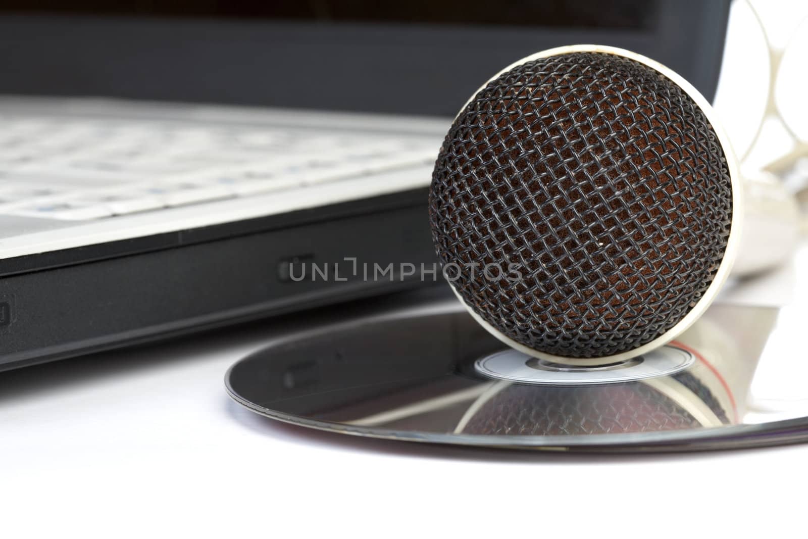 The microphone lays on notebook near to compact discs
