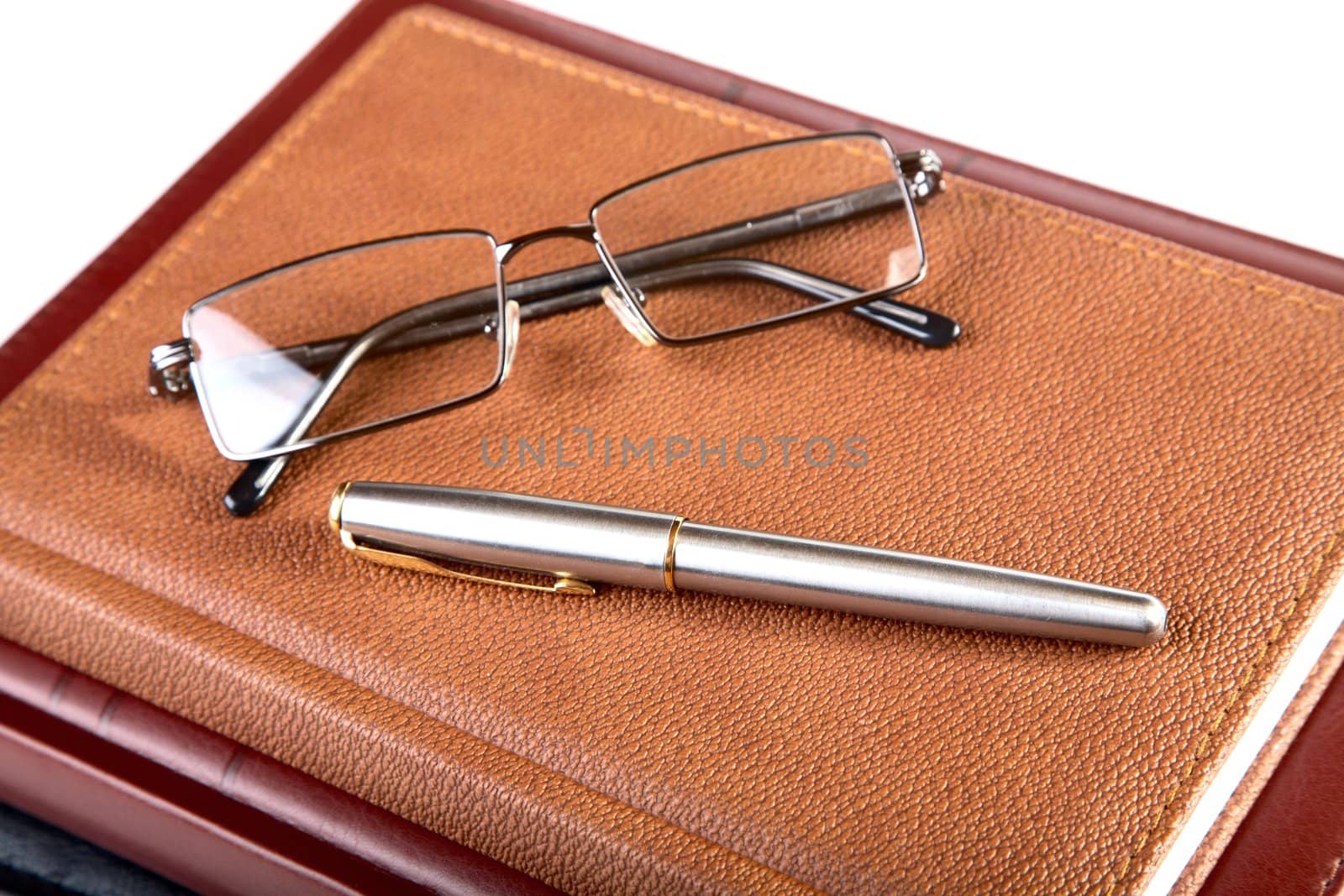 Organizer glasses and fountain pen on a white background