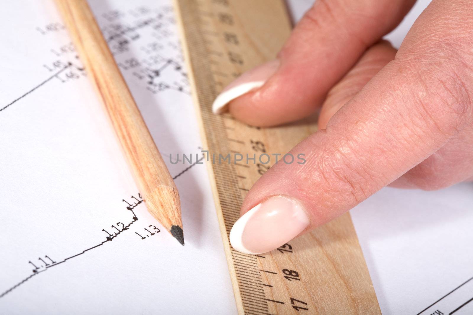 Female hands with a ruler and  pencil on the drawing