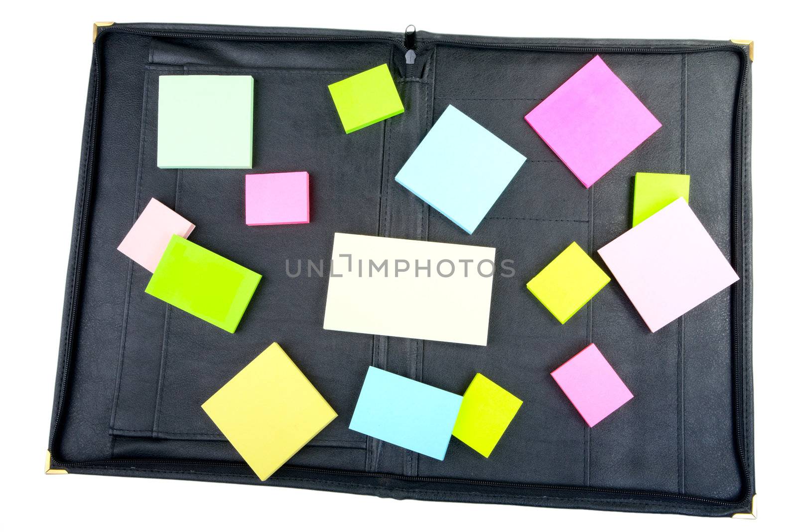 Leather folder with the scattered piles of stickers on a white background