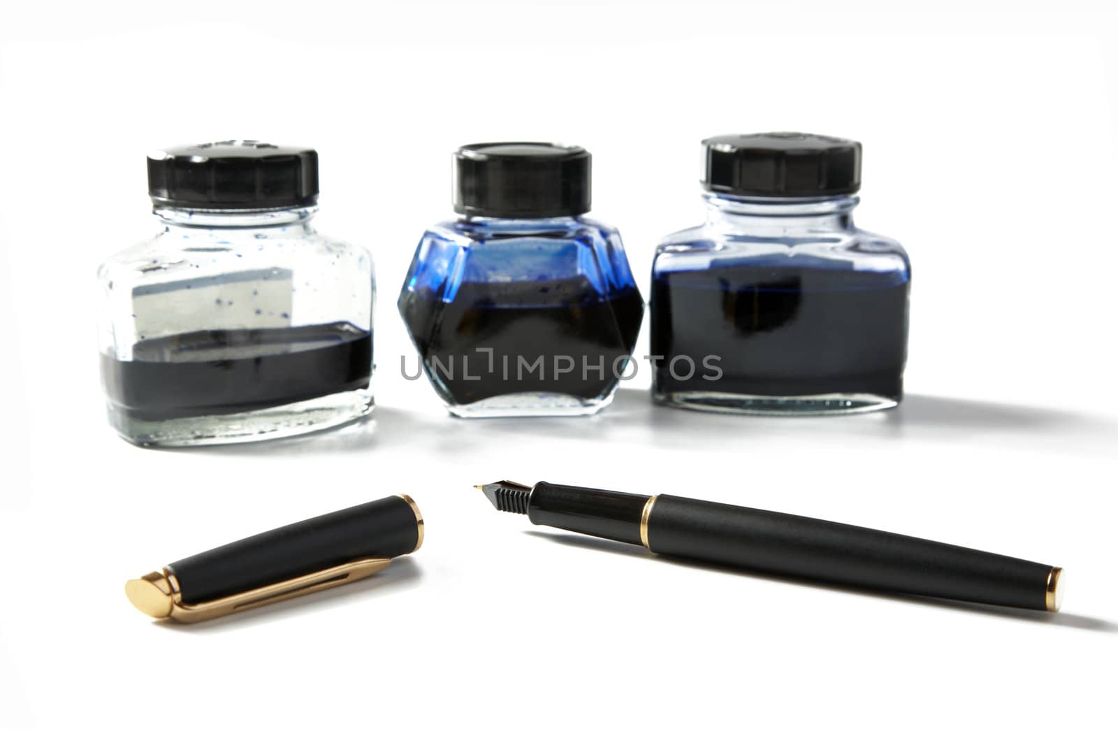 Small bottles with ink and  fountain pen on a white background