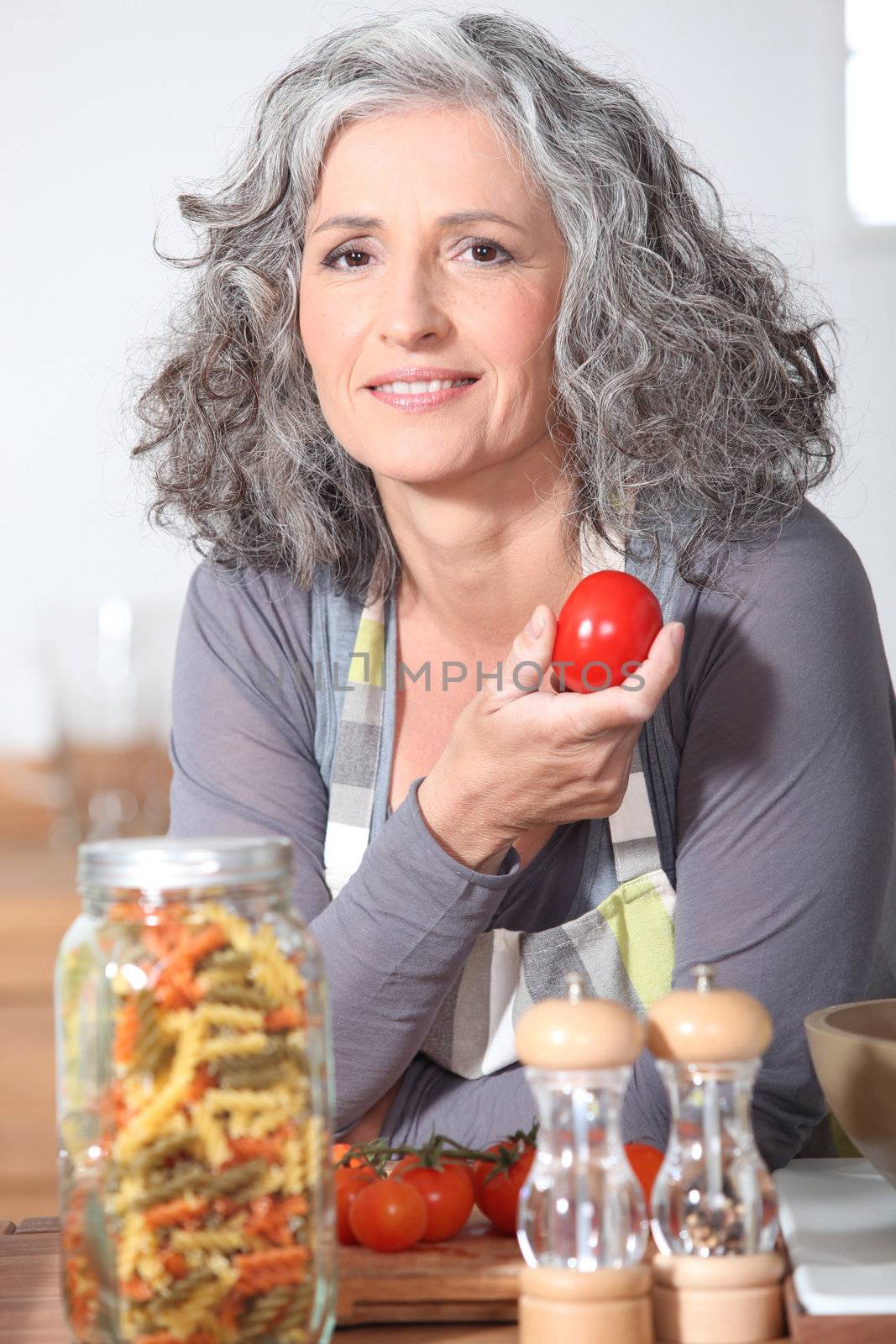 Woman with fresh tomatoes and a jar of pasta by phovoir