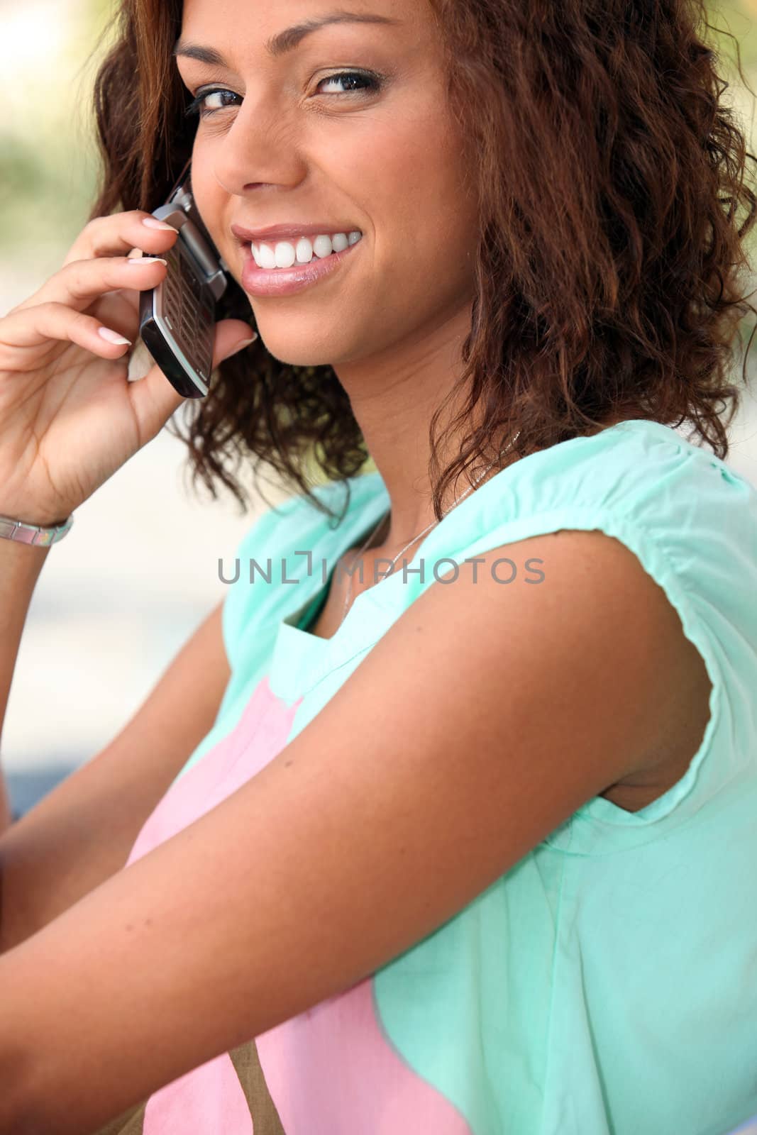 Young woman using a mobile phone by phovoir