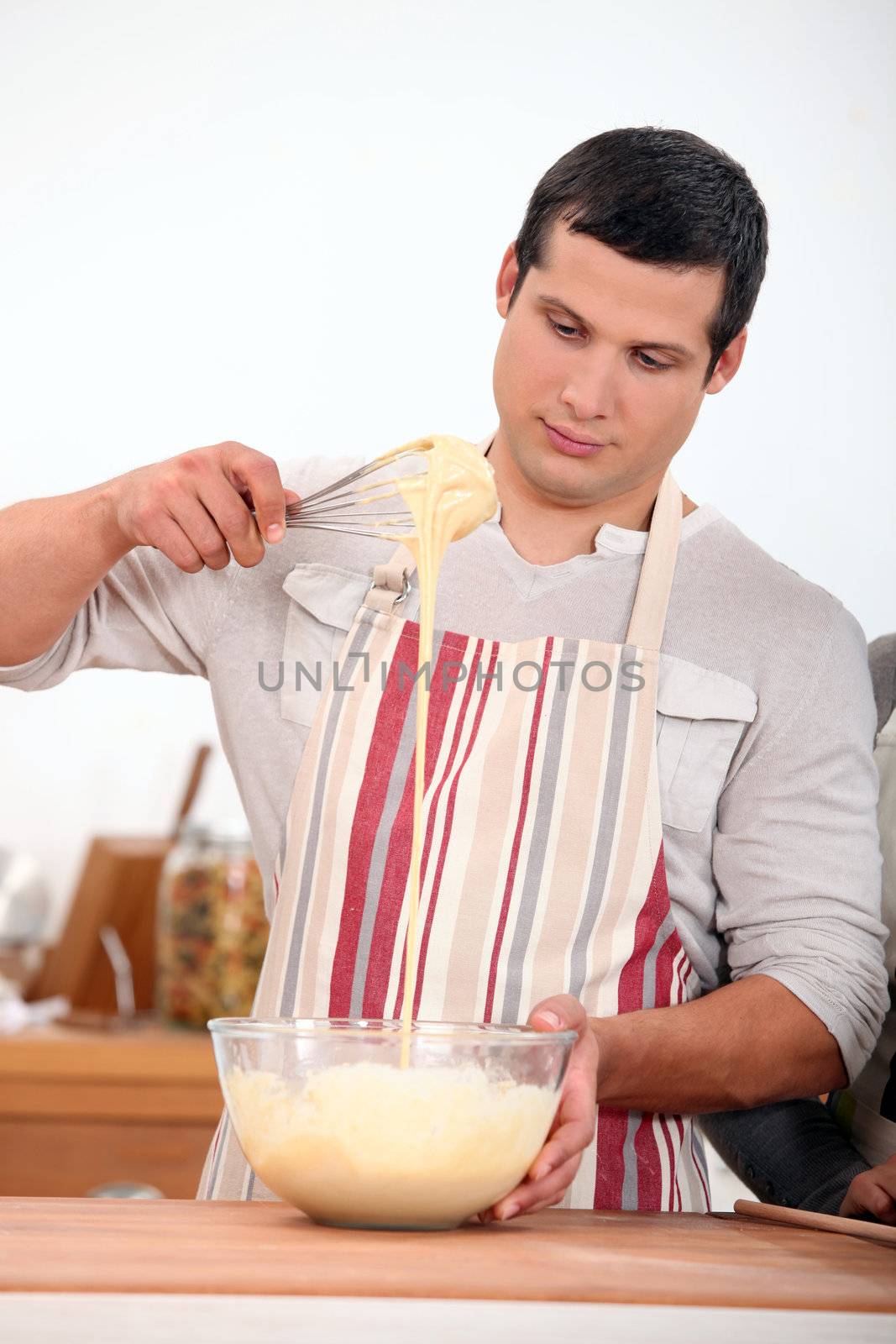 young man wearing an apron and doing dough by phovoir