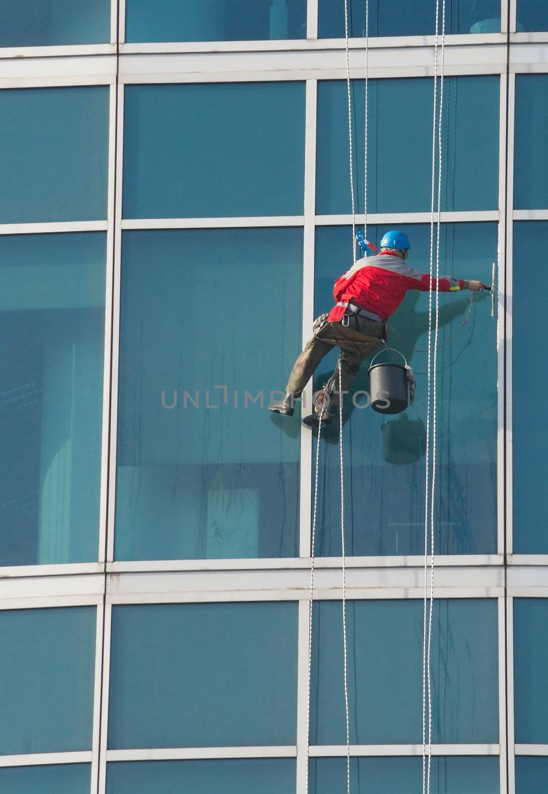 Climber - window cleaner perform the work at wall of an office building