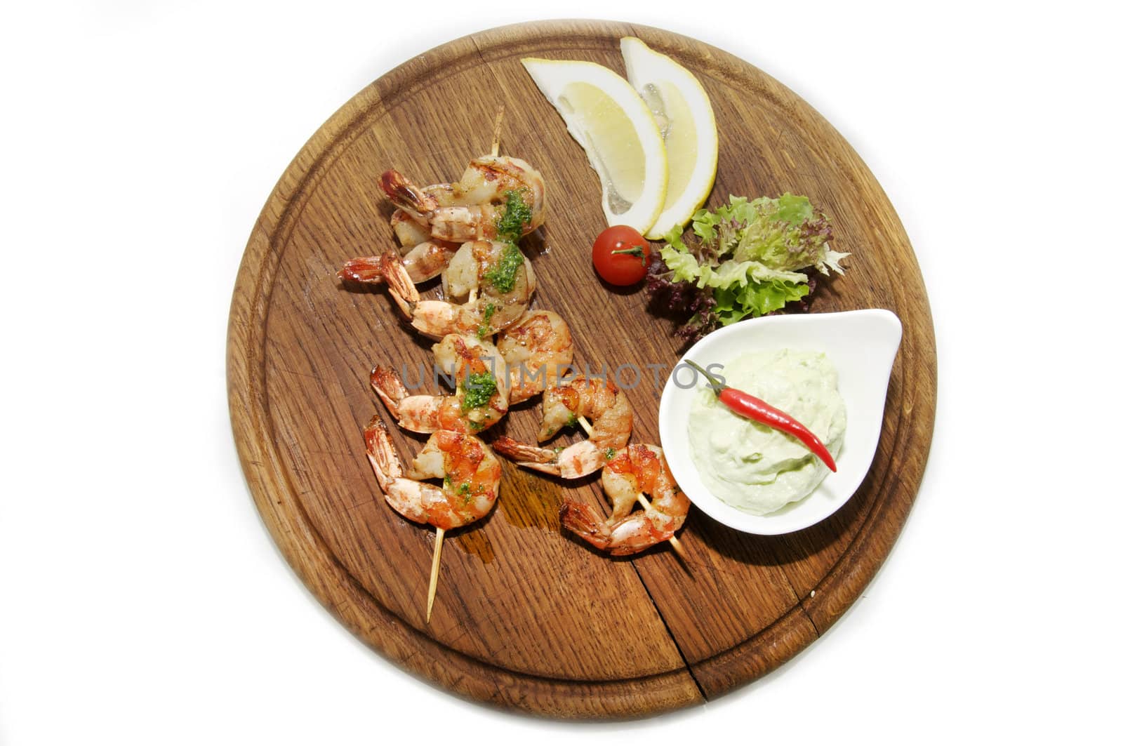 skewers of shrimp on a large wooden platter with garnish