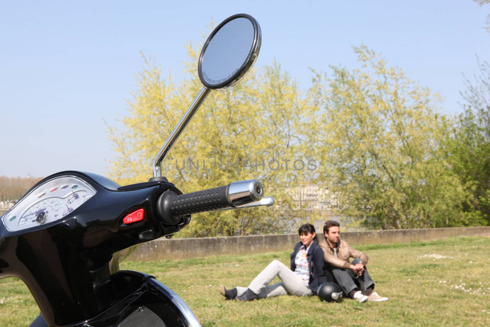 Couple sat near scooter by phovoir
