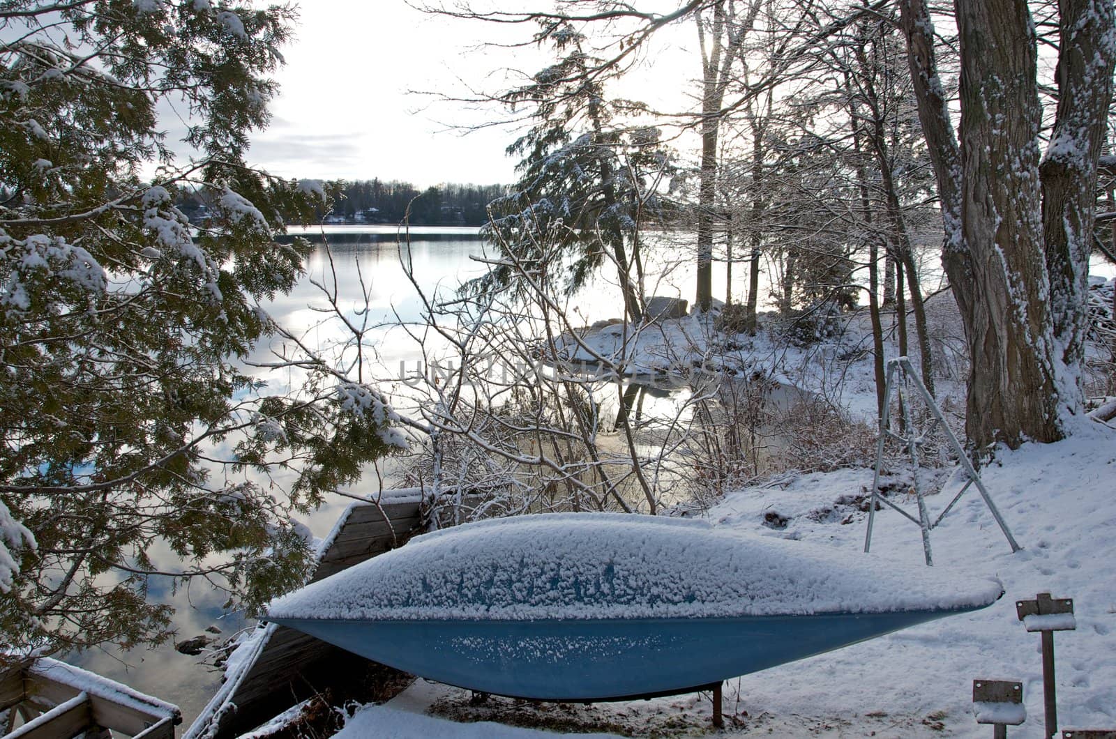 A canoe pulled out of a Canadian lake in winter time.