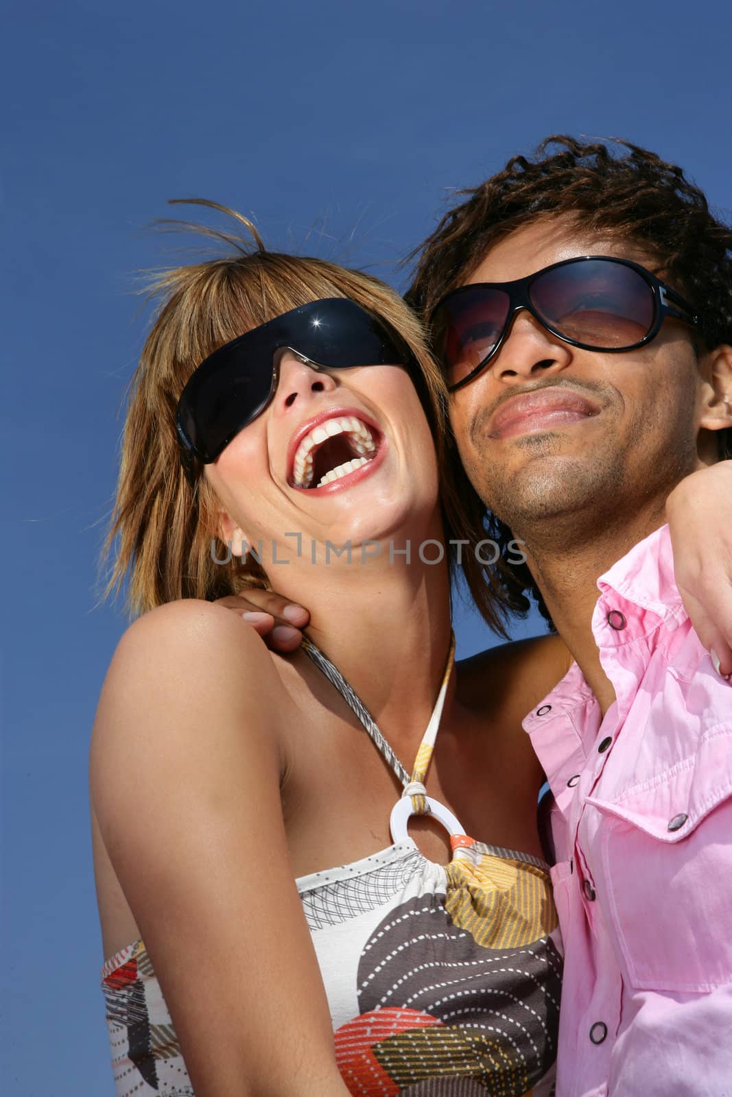 Couple laughing together in the sunshine by phovoir
