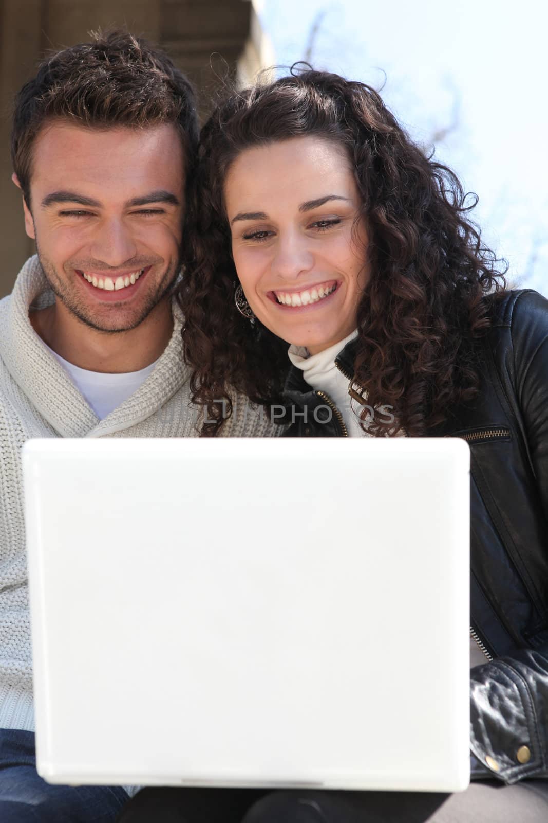 Couple outdoors with laptop by phovoir