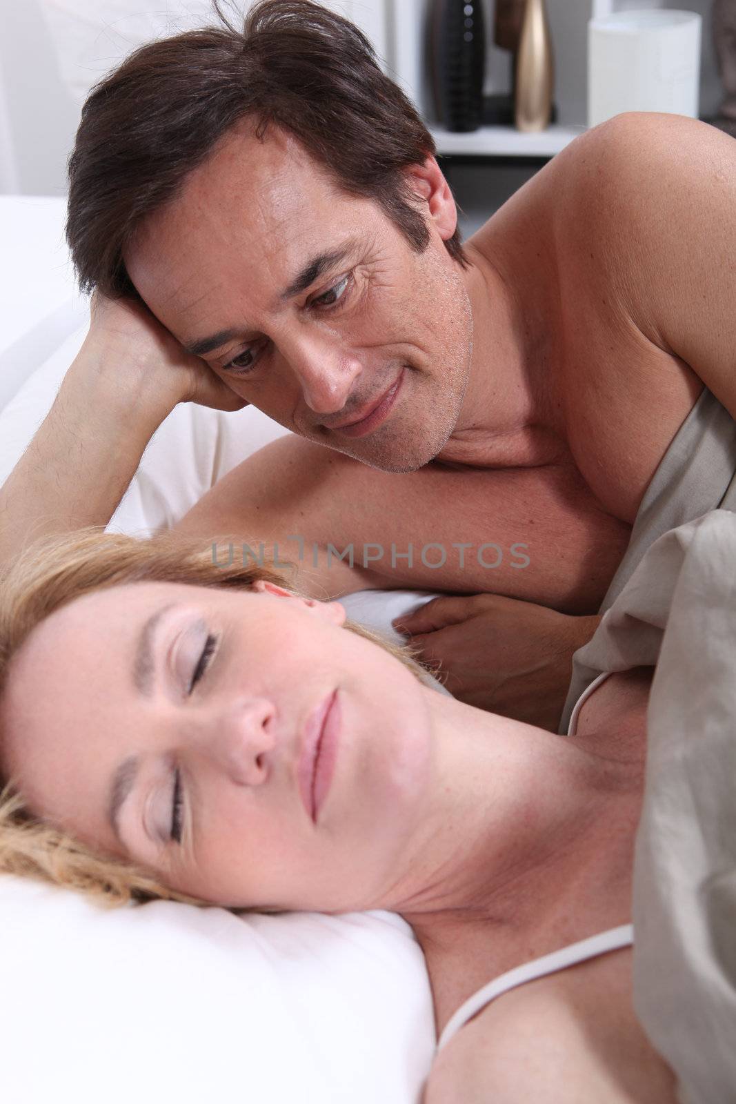 Man watching woman sleeping by phovoir