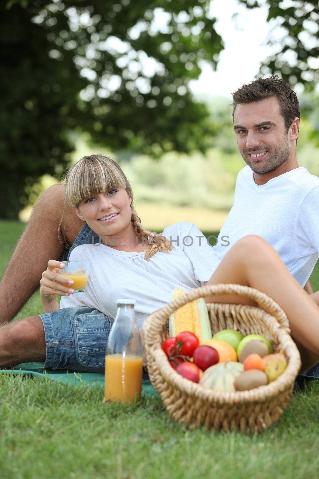 couple having picnic in the park by phovoir
