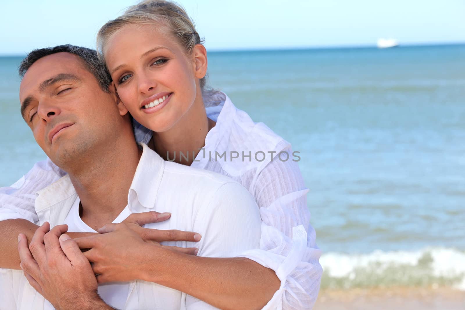 Loving couple on a beach by phovoir