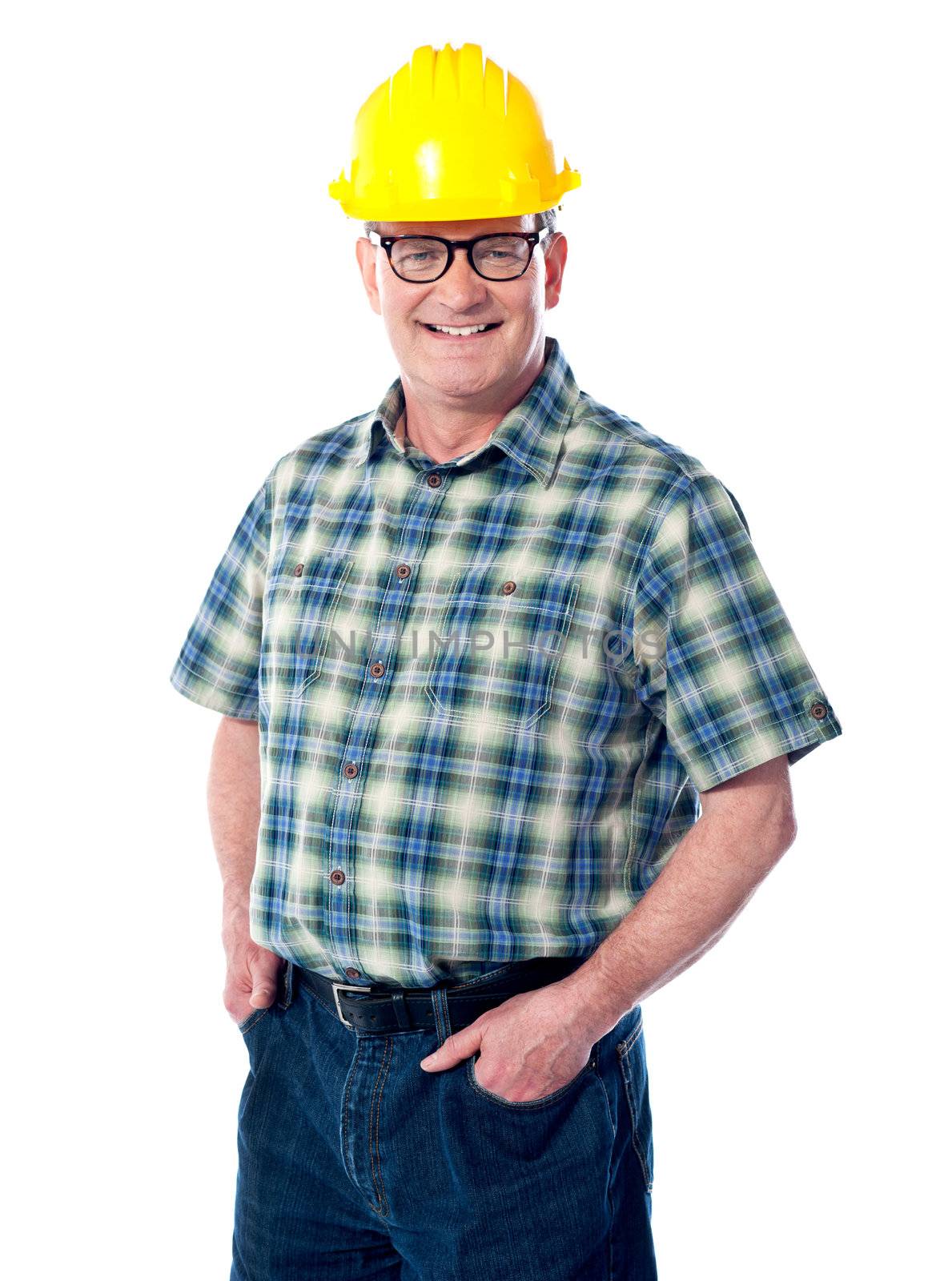 Smiling matured architect posing with hands in pocket. Wearning hard-hat