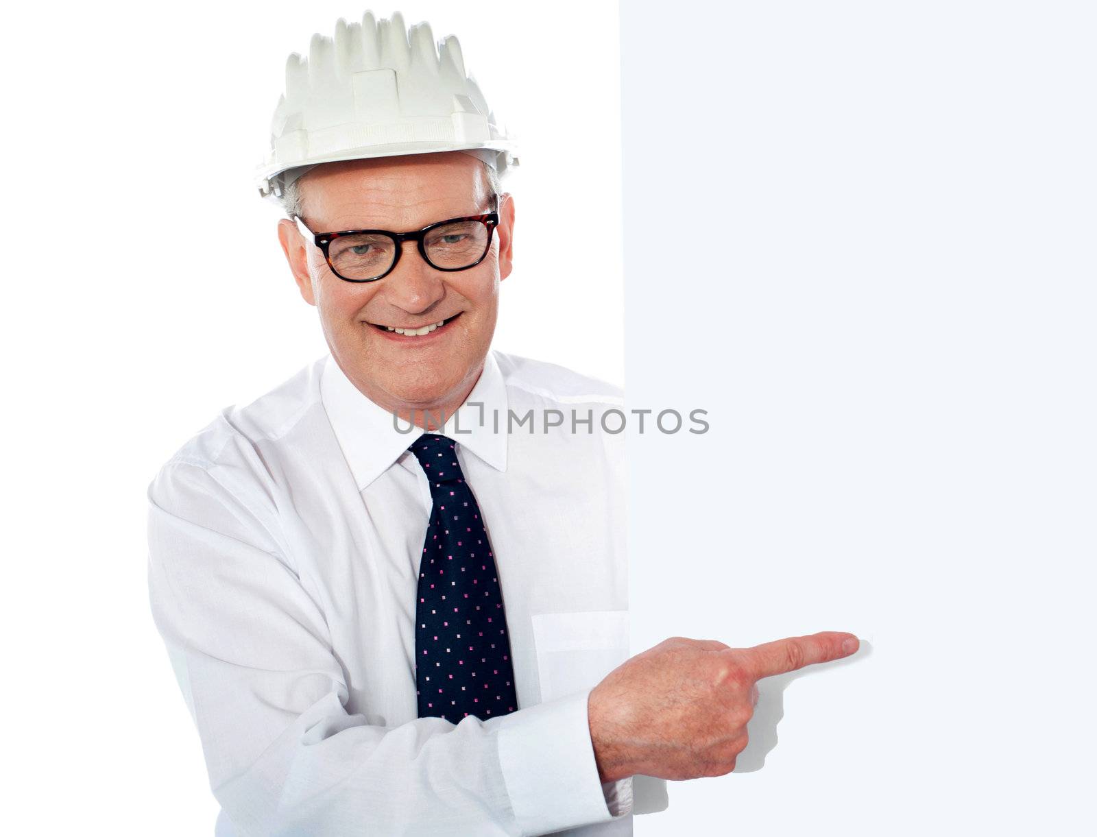Senior man in white construction helmet holding placard by stockyimages