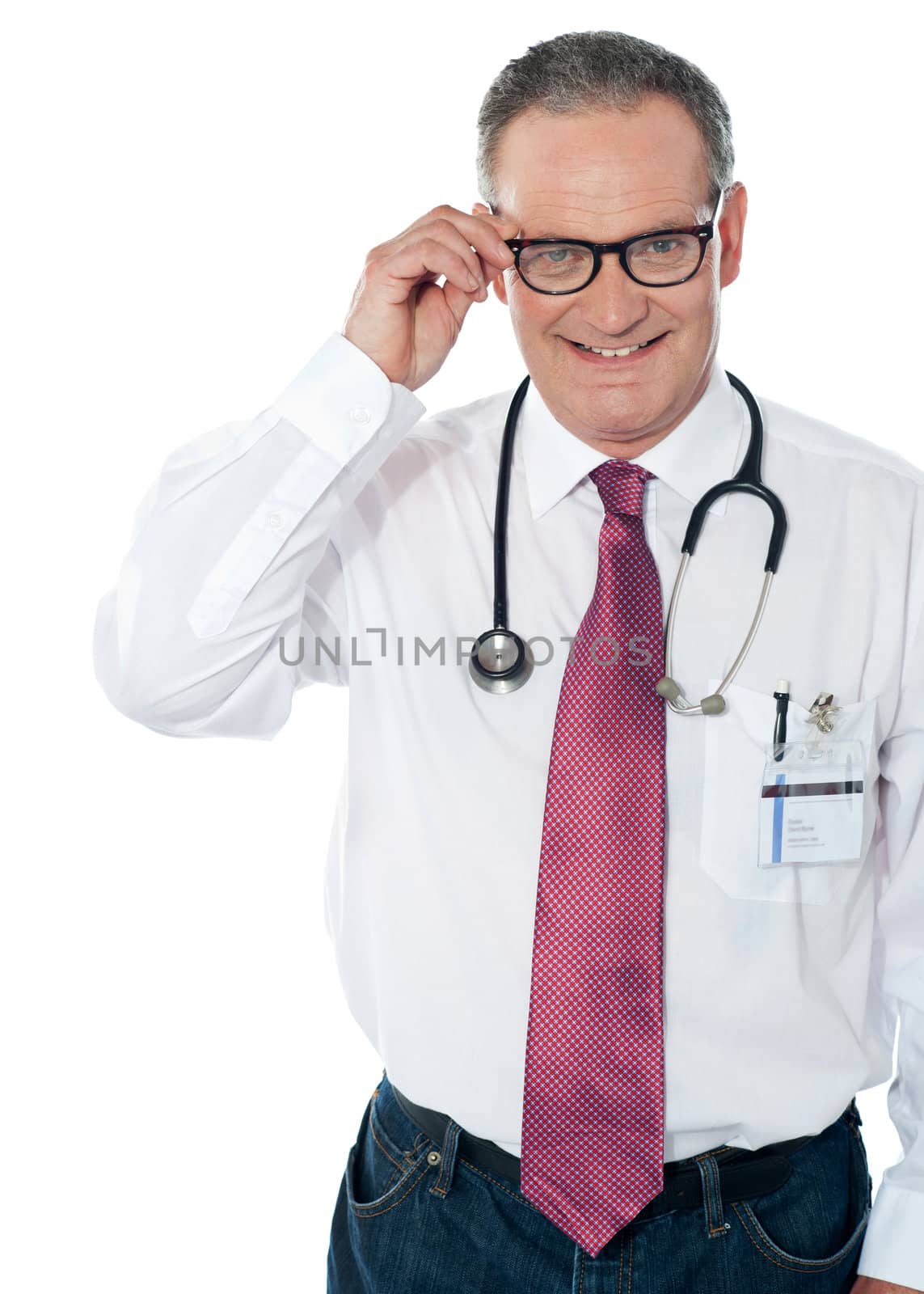 Medical professional looking at camera while holding his eyeglasses. Indoors studio shot