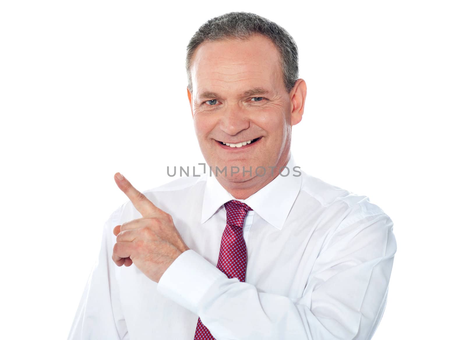 Smiling businessman pointing away. Copyspace concept