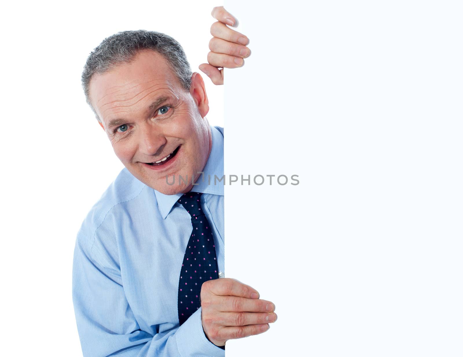 Portrait of a man peeking behind empty white billboard