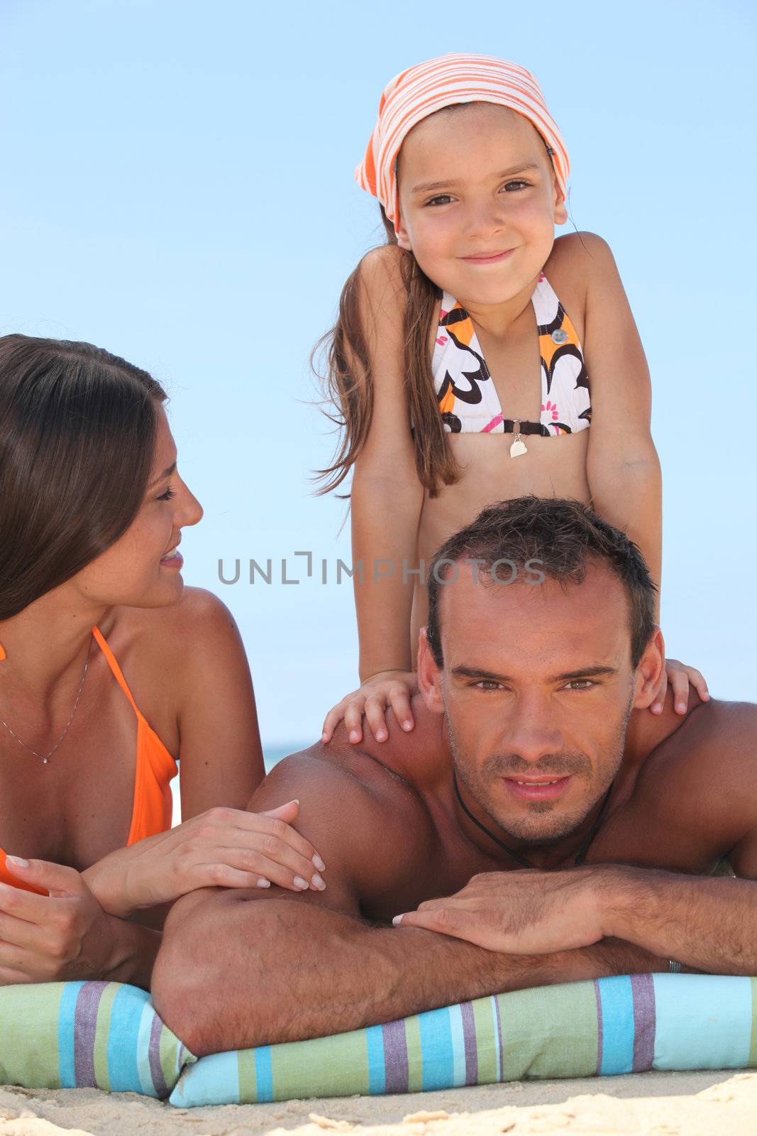 Family enjoying a day out at the beach by phovoir