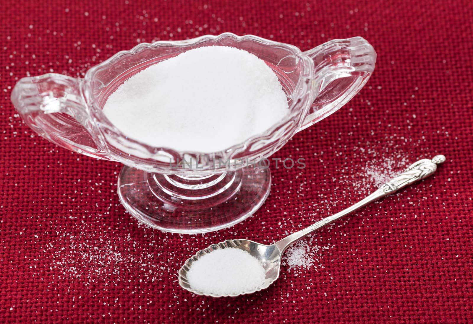 Table salt crystals in cut glass bowl on red tablecloth