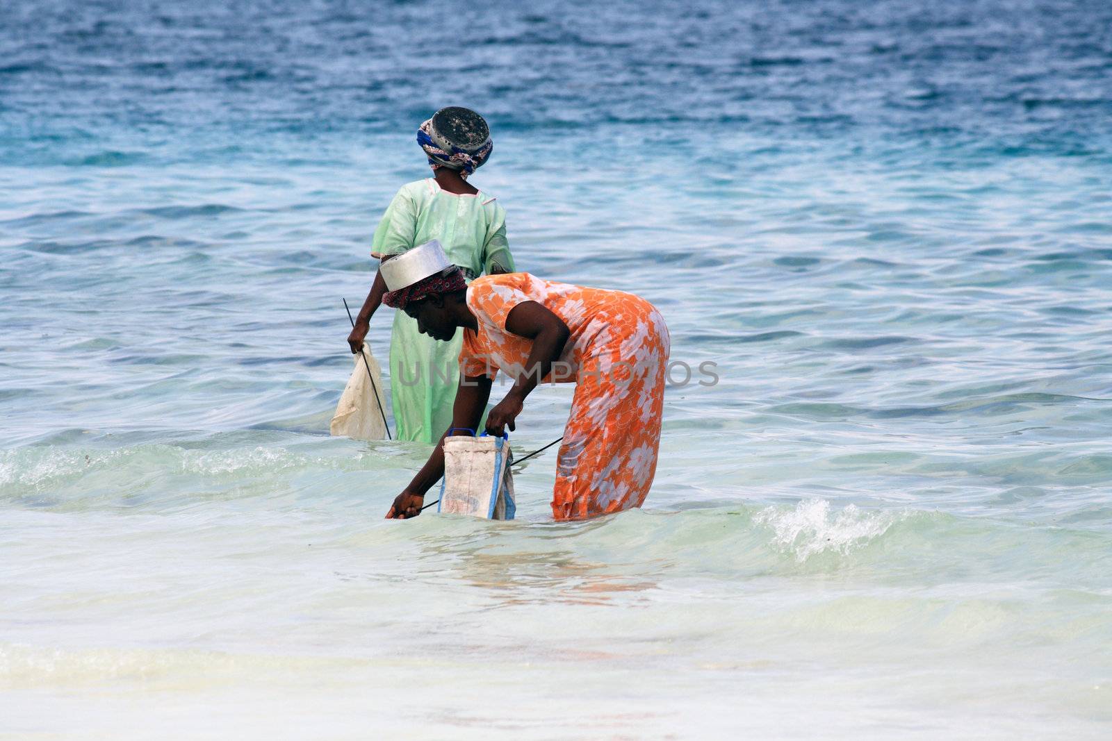 Women with colorful clothes fishing in Zanzibar