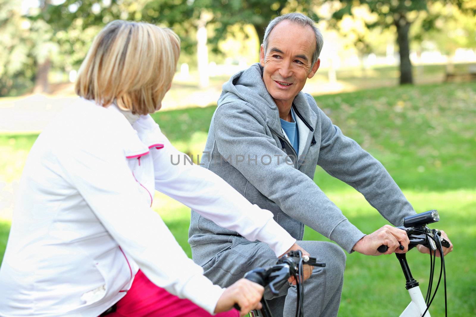 Senior couple on a bike ride by phovoir