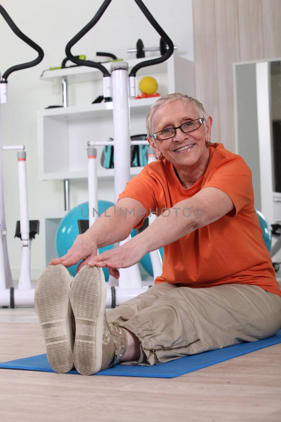 Older woman working out on a gym mat