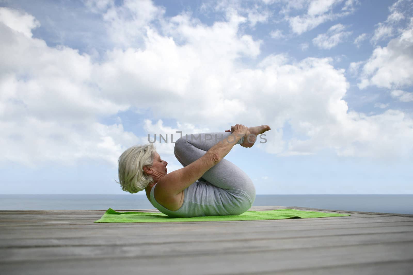 senior woman making exercises on the beach