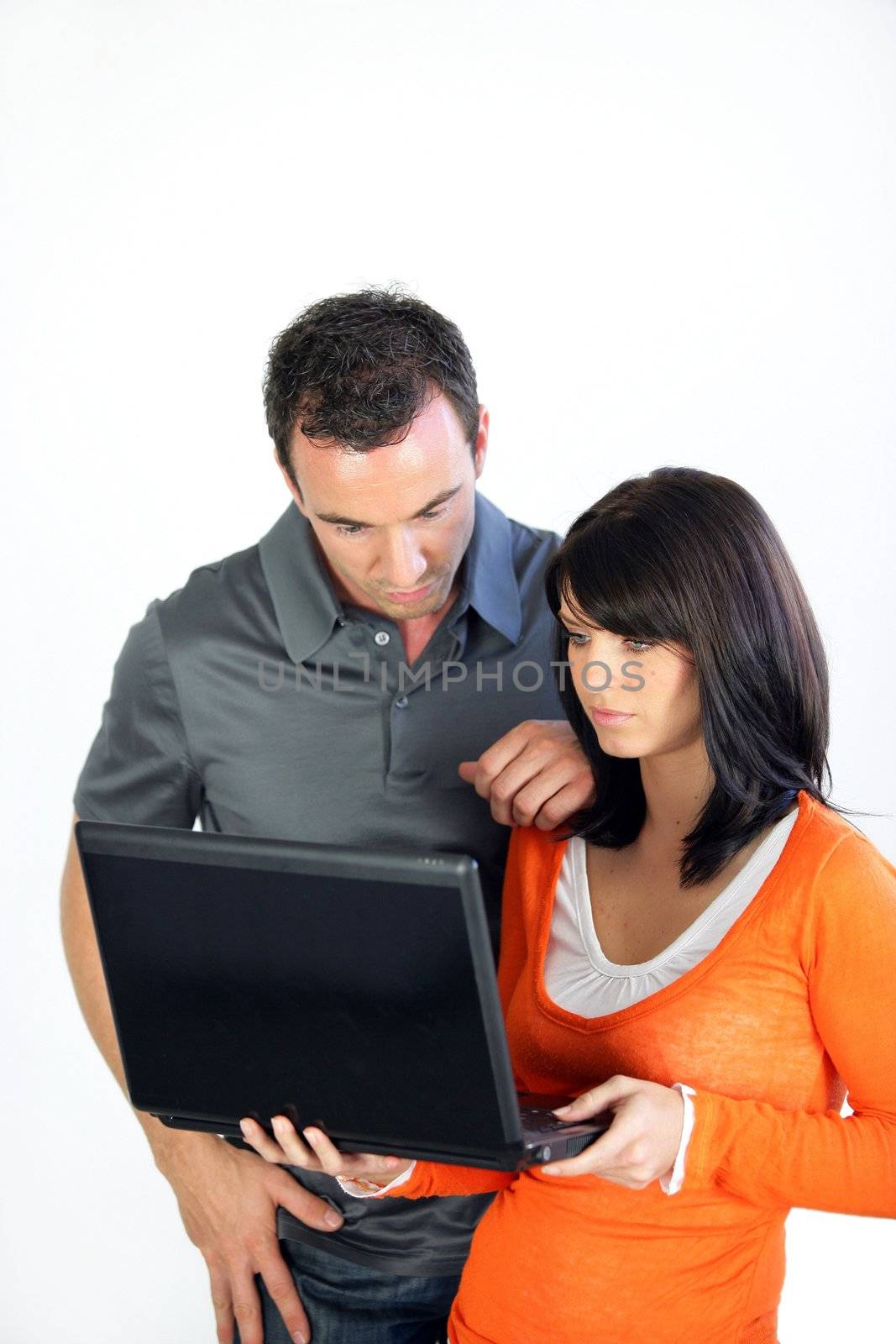 Couple looking at a laptop by phovoir