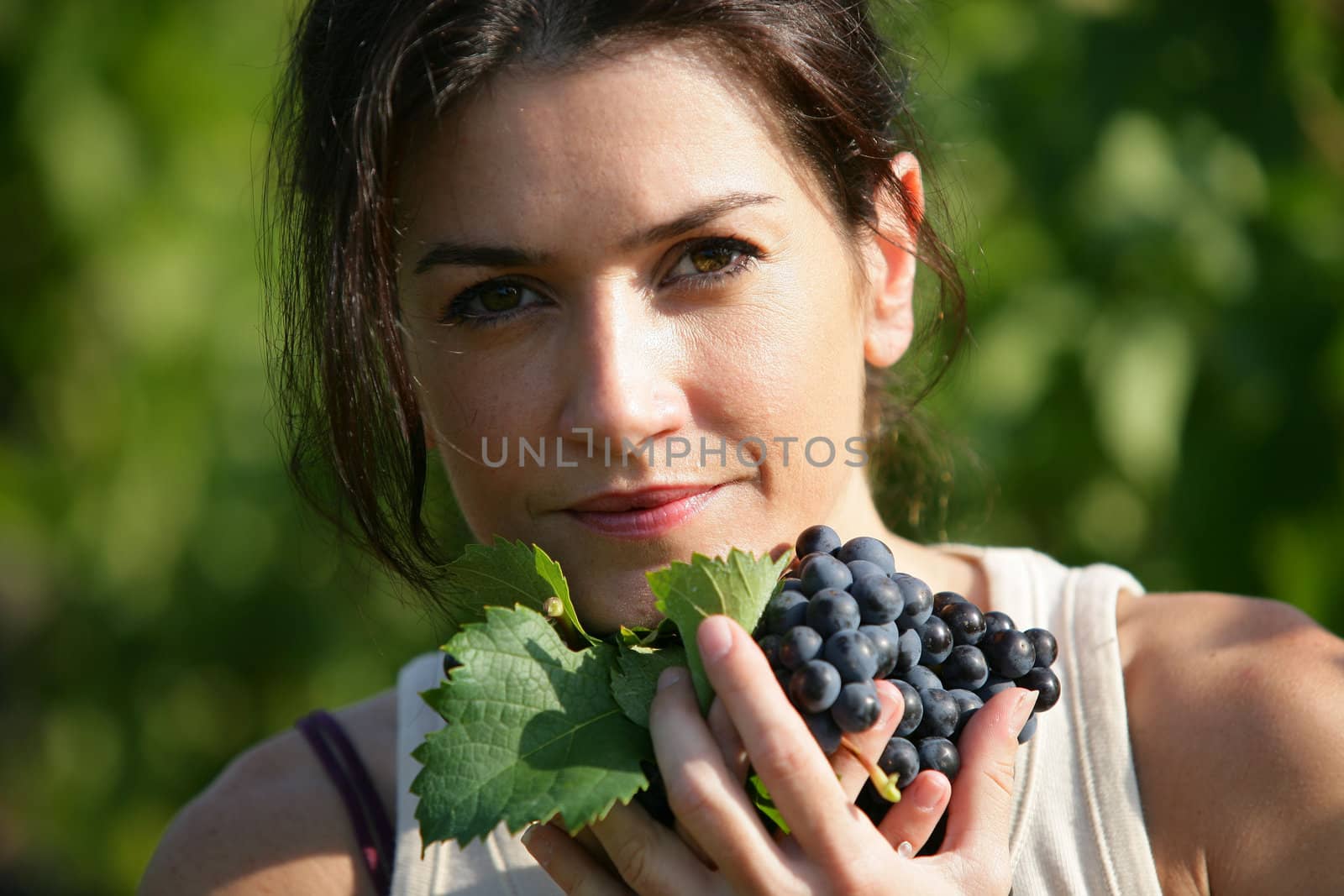 Woman holding a bunch of grapes by phovoir
