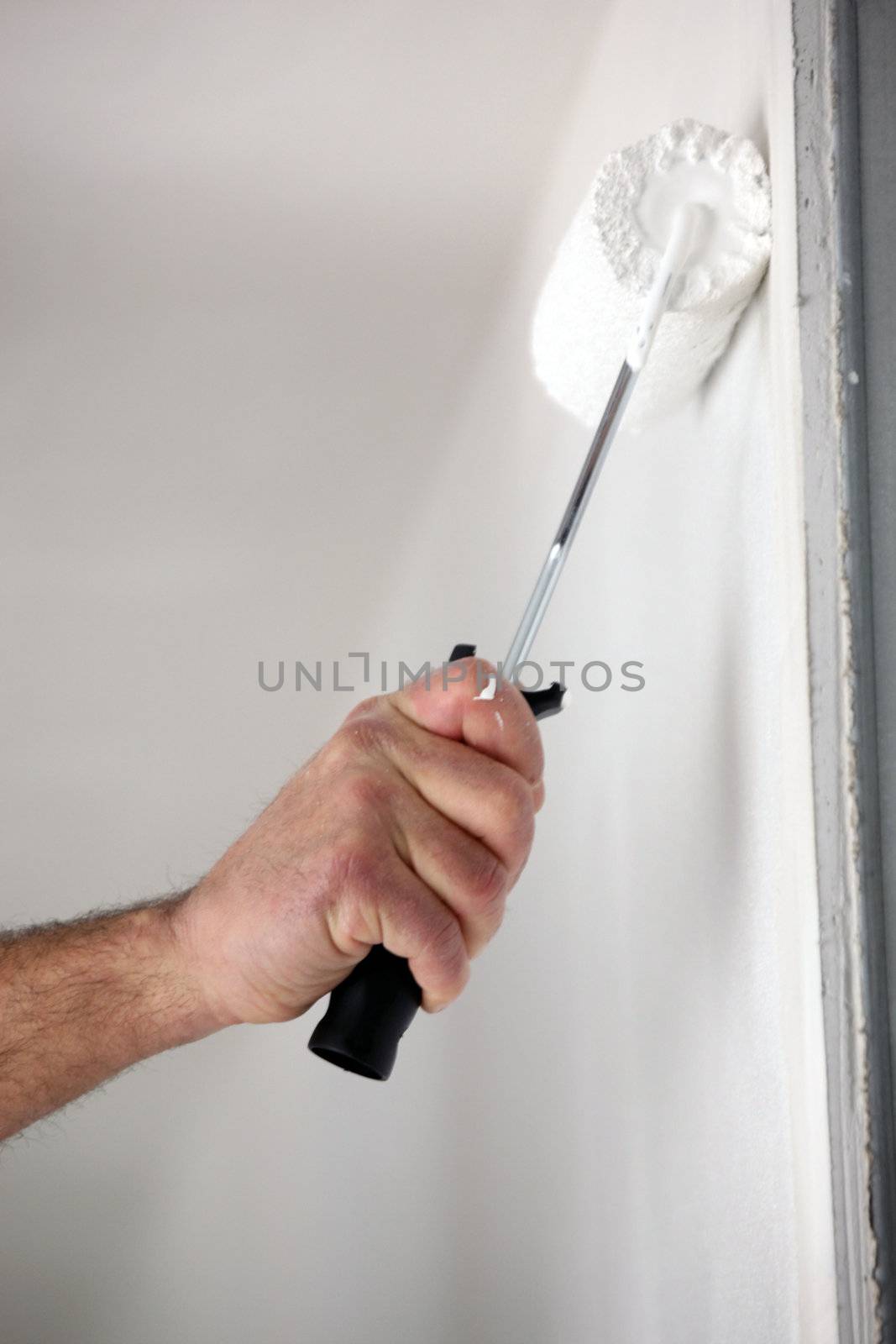 Close-up of man painting wall with roller