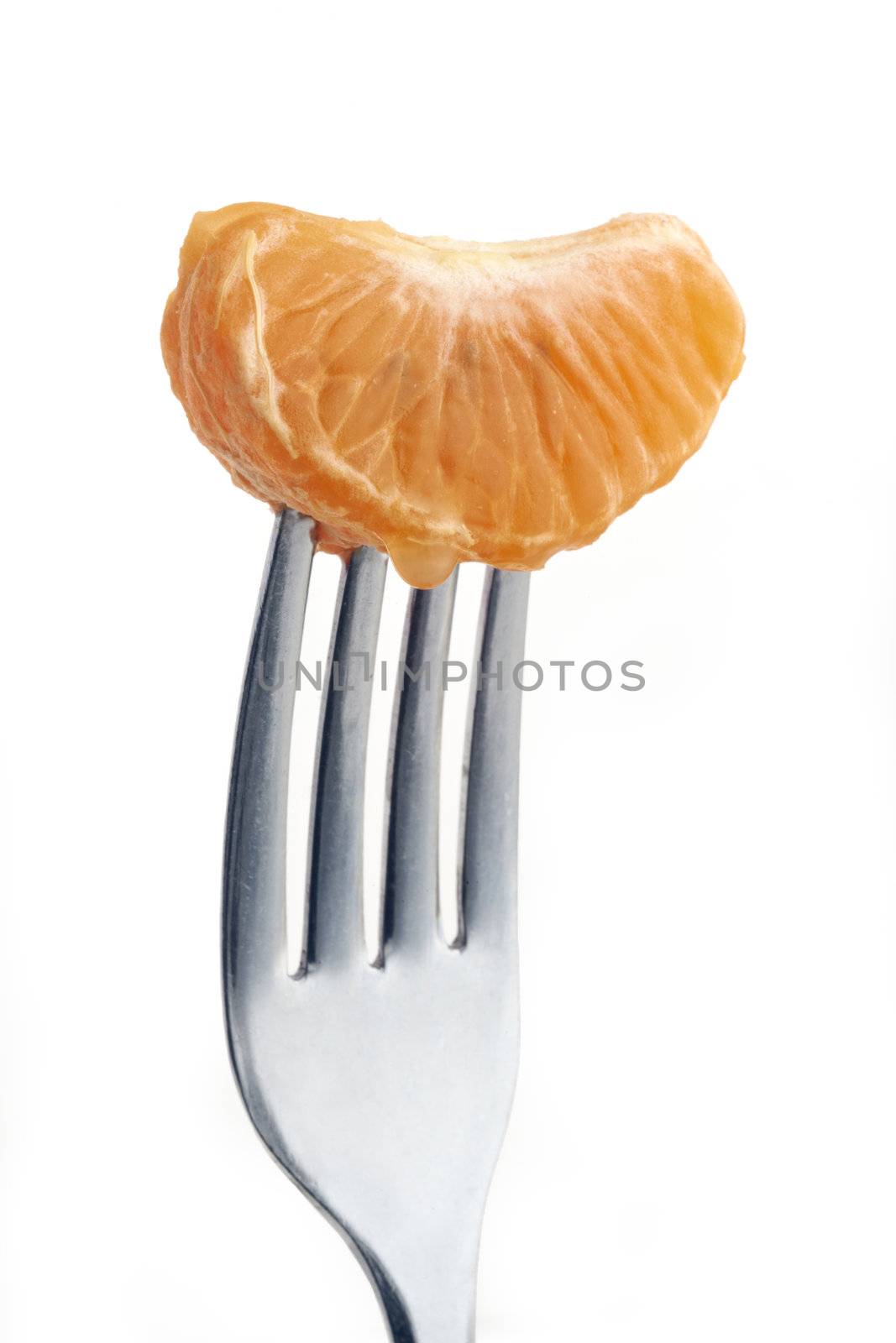 slice of orange pierced on a fork against plain background