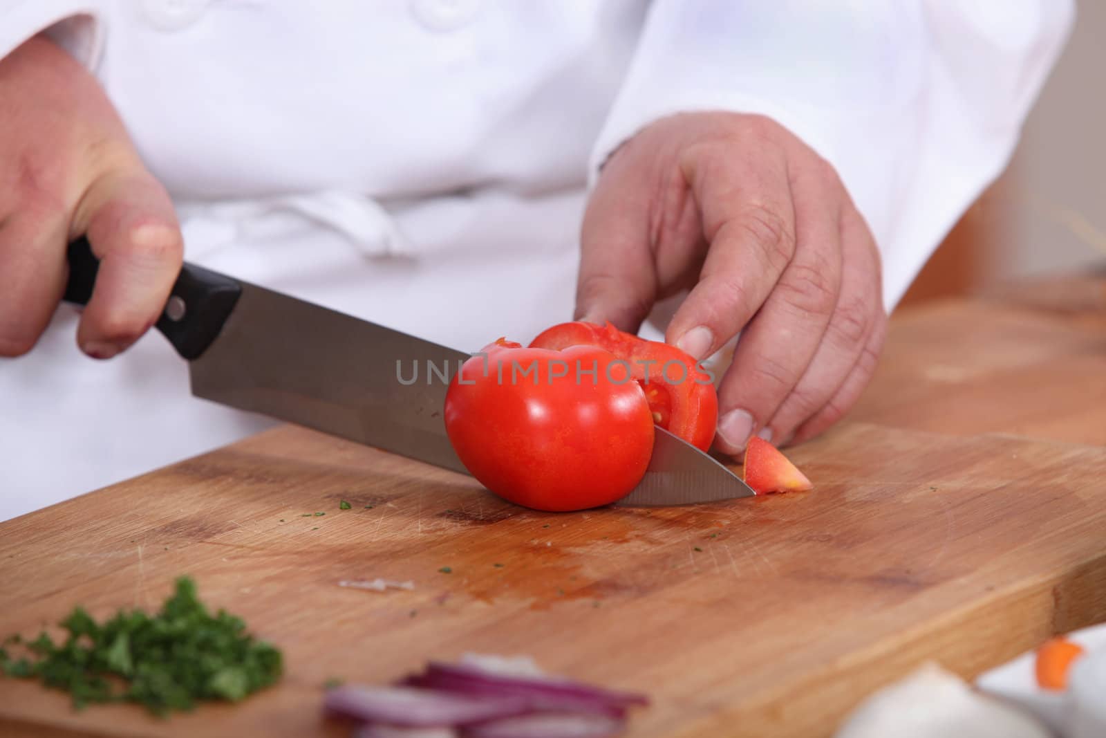 Cook cutting a tomato