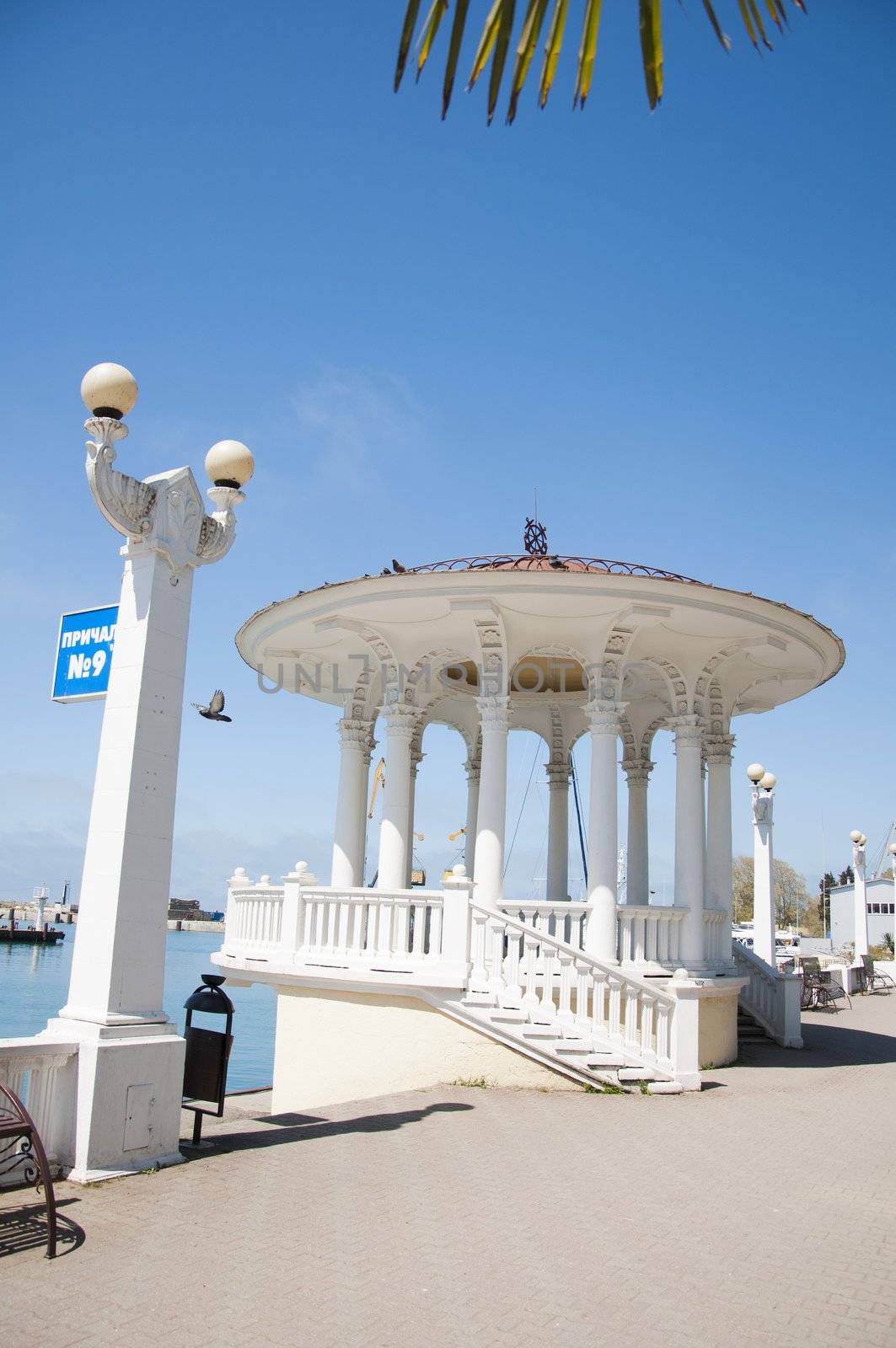 The white concrete gazebo in marine near the sea