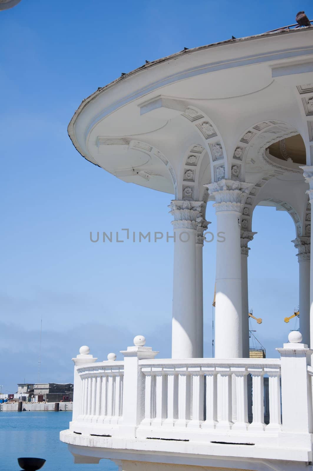 The white concrete gazebo in marine near the sea