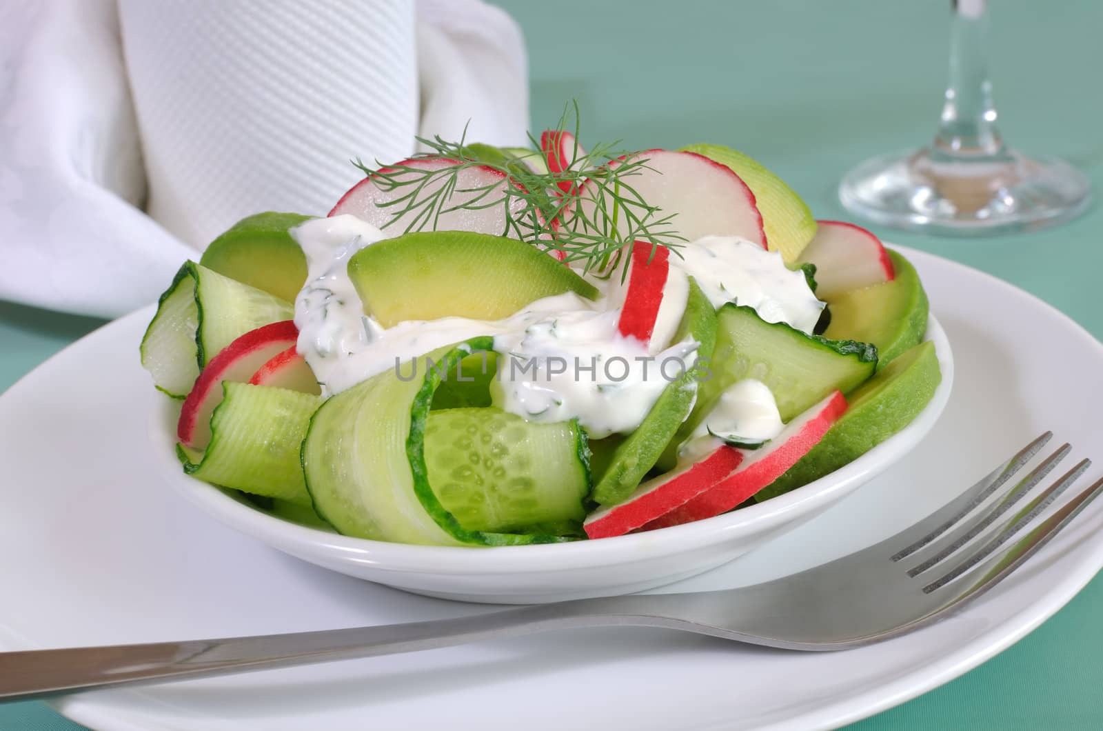 Cucumber salad with radish and avocado cream sauce and dill