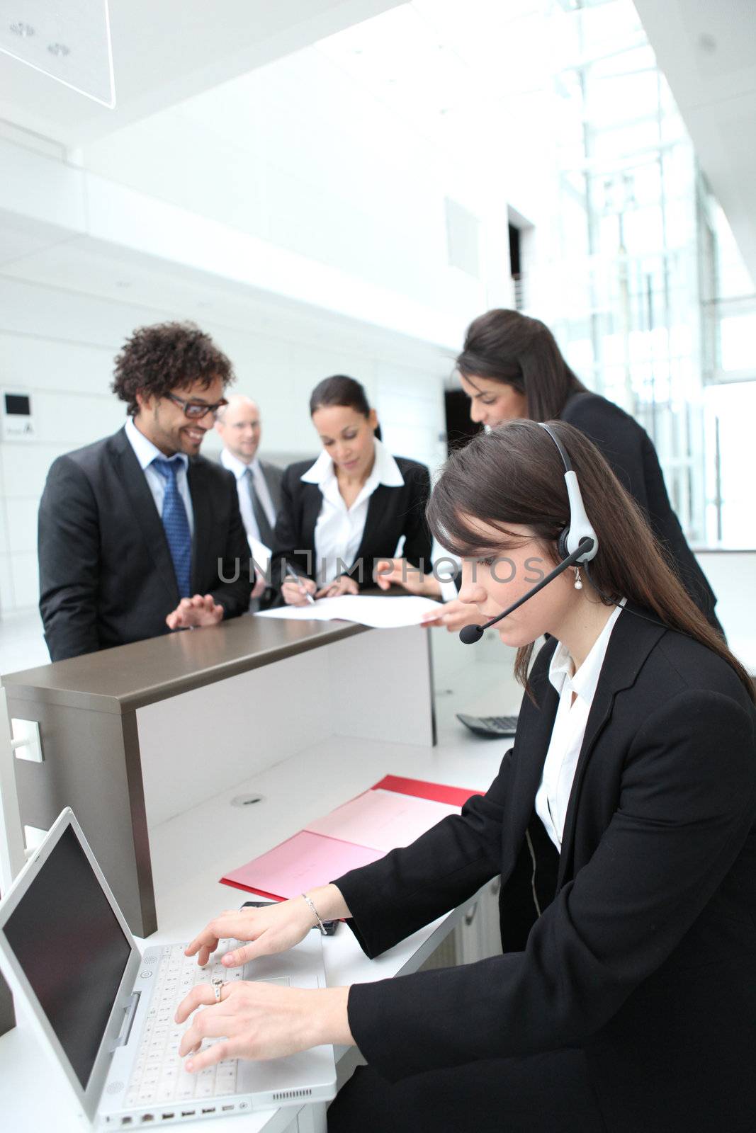 Female receptionist using a headset and laptop computer